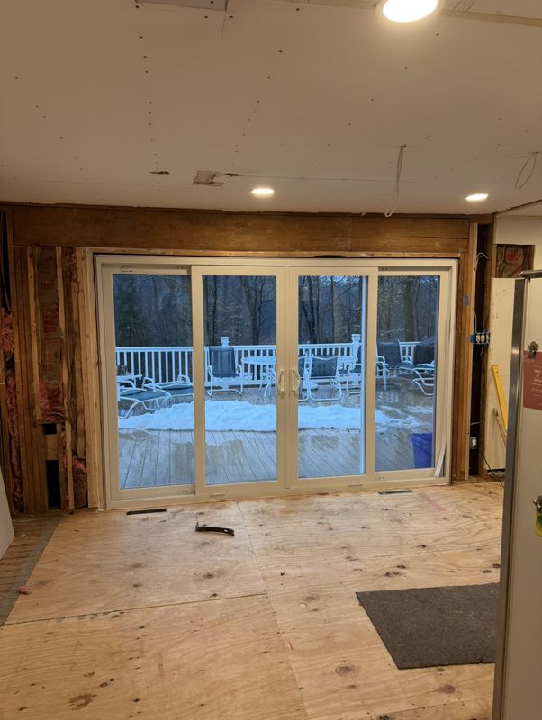 During: new sliding doors set into the opened wall, framing exposed