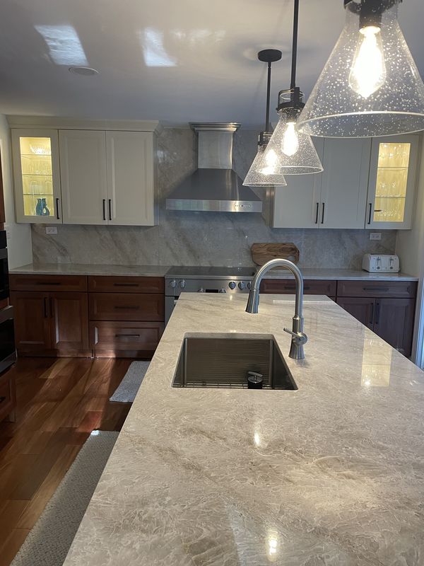 Quartzite island with undermount sink under seeded-glass pendants