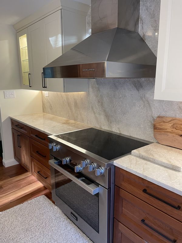 Range, hood and lit glass-front upper cabinets